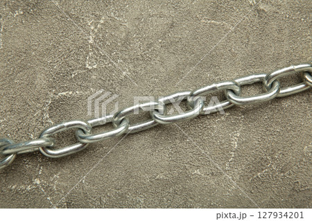 Iron chain of light metal on grey background. Iron chain of light metal on grey background. 127934201