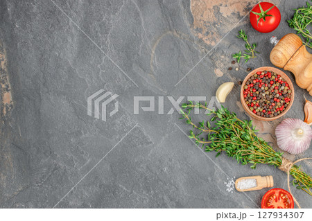A rustic flatlay of herbs, spices, and vegetables on a dark stone background, ideal for cooking, seasoning, or Mediterranean cuisine themes A rustic flatlay of herbs, spices, and vegetables on a dark stone background, ideal for cooking, seasoning, or Mediterranean cuisine themes 127934307
