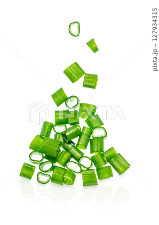 Freshly chopped green onion slices falling in mid-air isolated on white background, cooking and garnish ingredient concept Freshly chopped green onion slices falling in mid-air isolated on white background, cooking and garnish ingredient concept 127934315