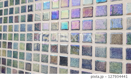 Prismatic mosaic tiles displaying rainbow spectrum and refracted light effect with vivid color transitions creating a vibrant atmosphere in spatial design 127934441