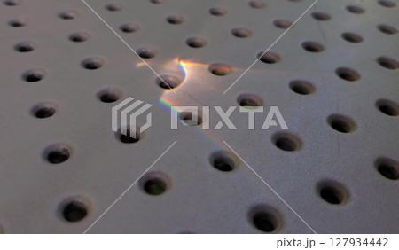 Rainbow sunny bunny atop dot pattern perforated surface 127934442
