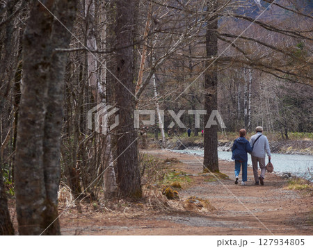 春の観光名所上高地の梓川の沿岸で散歩するシニア夫婦の姿 春の観光名所上高地の梓川の沿岸で散歩するシニア夫婦の姿 127934805