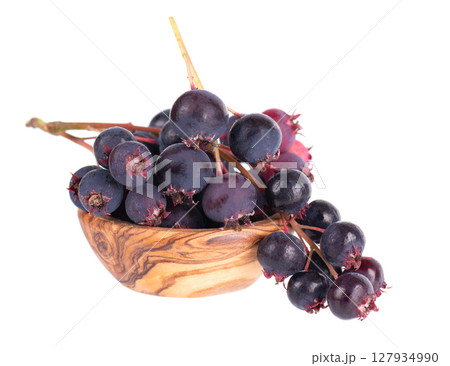 Serviceberry isolated on white background. Saskatoon, amelanchier, shadbush, juneberry, irga or sugarplum ripe berries in wooden bowl. 127934990