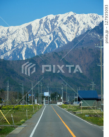 春の観光名所長野県の白馬の農家と立山連峰の雪景色 春の観光名所長野県の白馬の農家と立山連峰の雪景色 127935093