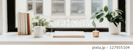 Home windowsill with lit candles and stacked books, minimalistic calm atmosphere 127935104