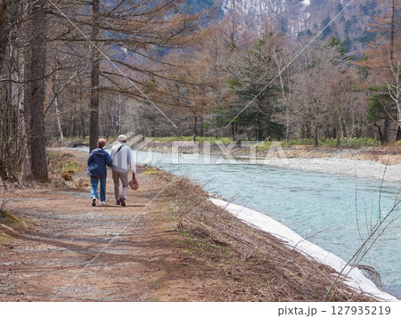 春の観光名所上高地の梓川の沿岸で散歩するシニア夫婦の姿 春の観光名所上高地の梓川の沿岸で散歩するシニア夫婦の姿 127935219