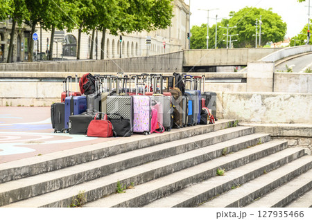 A large number of suitcases and bags are standing in the open air, in the city, on the edge of the steps. Horizontal photo A large number of suitcases and bags are standing in the open air, in the city, on the edge of the steps. Horizontal photo 127935466