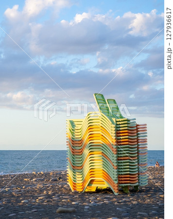 Beach equipment folded. Sunbeds on top of each other. Concept of the end of the beach season. Autumn at sea. Beach equipment folded. Sunbeds on top of each other. Concept of the end of the beach season. Autumn at sea. 127936617