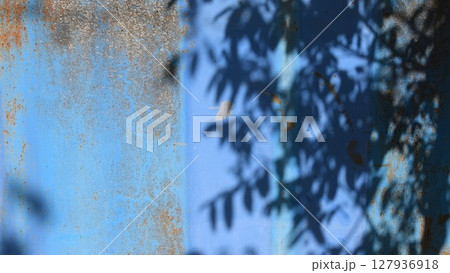 Shadow pattern of fluttering tree on rusty blue painted background with copy space 127936918