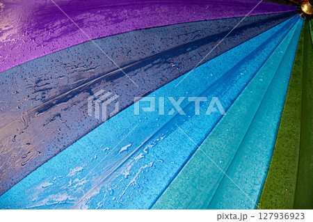 Raindrops on blue purple shades umbrella closeup wet fabric texture 127936923