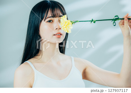 花を持つ若い女性 127937117