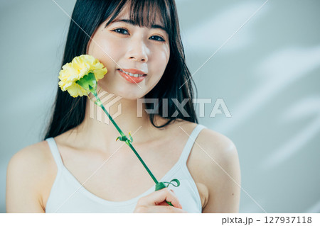花を持つ若い女性 127937118