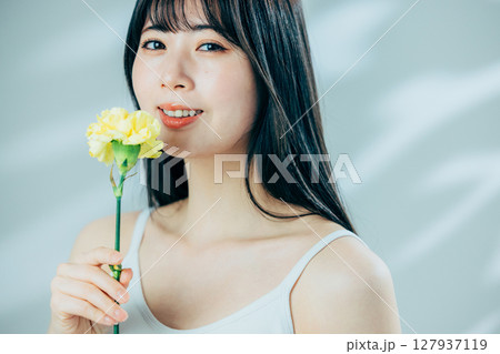 花を持つ若い女性 127937119