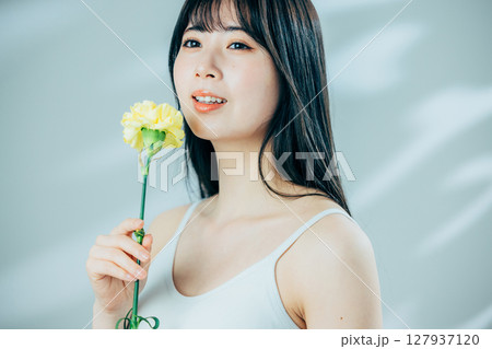 花を持つ若い女性 127937120