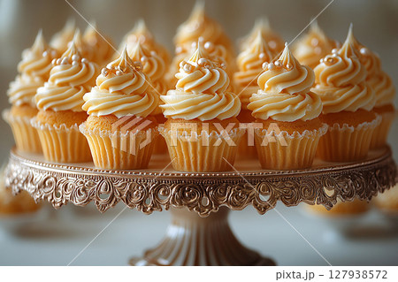 Various cakes in yellow tones on dessert stand with soft lighting. 127938572
