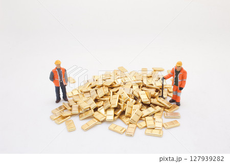 Miniature Workers Surrounding a Pile of Golden Bars Miniature Workers Surrounding a Pile of Golden Bars 127939282