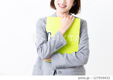 ファイルを抱えて微笑むスーツ姿のミドル女性 127939432