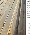 Lumber - decking in sunny natural light. Perspective view. Natural building materials made of wood. Texture of processed wood 127940708