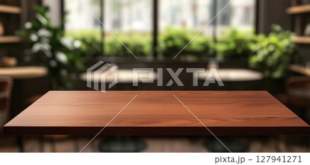Empty Wooden Table Presents Cozy Cafe Interior with Greenery, Perfect for Display or Presentation. Empty Wooden Table Presents Cozy Cafe Interior with Greenery, Perfect for Display or Presentation. 127941271