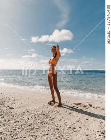 Gorgeous woman in bikini with tanned body posing on sea beach. 127941488