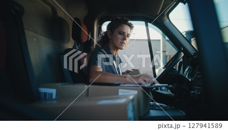Female Delivery Truck Driver Using Tablet Computer, Filling Out Papers, Delivering Online Orders 127941589