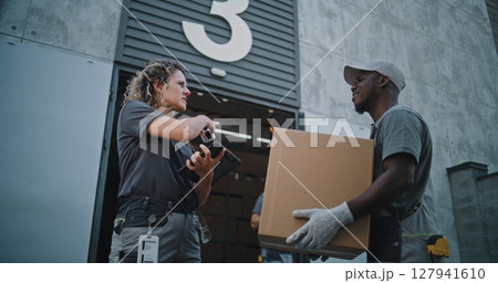 Diverse Employees Carrying Cardboard Boxes to Logistics Warehouse. Female Manager Scanning Parcels Diverse Employees Carrying Cardboard Boxes to Logistics Warehouse. Female Manager Scanning Parcels 127941610