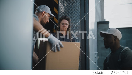 Multiethnic Workers Unloading Cardboard Boxes. Female Manager Using Tablet Computer and Scanner Multiethnic Workers Unloading Cardboard Boxes. Female Manager Using Tablet Computer and Scanner 127941791