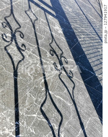 Intricate shadows cast on polished marble surface creating an artistic visual effect Intricate shadows cast on polished marble surface creating an artistic visual effect 127941917