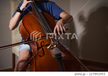 Close-Up of a Cellist Playing a Cello in a Warmly Lit Room 127941955