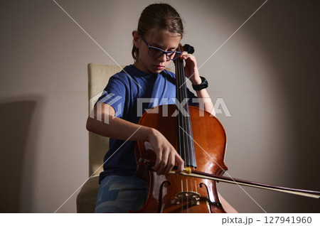 Young Musician Playing the Cello in Focused Practice Session 127941960