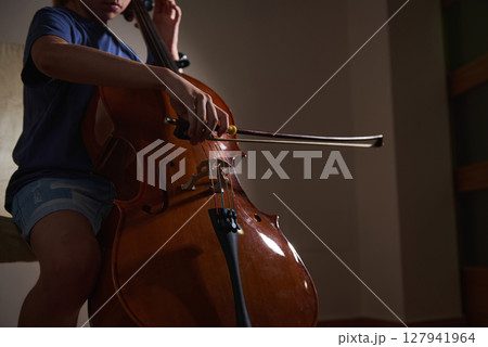 Close-Up of a Musician Playing a Cello in a Dimly Lit Room 127941964