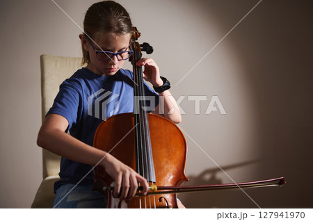 Young Musician Playing the Cello in a Studio Setting Young Musician Playing the Cello in a Studio Setting 127941970