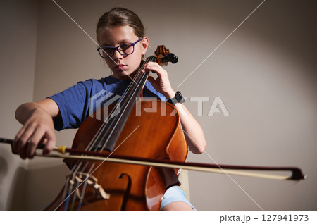 Young Musician Playing a Cello Concentratedly in a Calm Interior 127941973