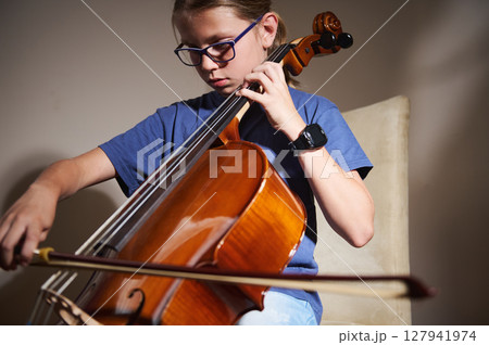 Young Musician Practicing Cello Performance in a Cozy Room 127941974