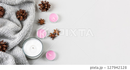Winter cozy composition of knitted sweaters, candles, pine cones, stars of star anise. Winter cozy composition of knitted sweaters, candles, pine cones, stars of star anise. 127942128