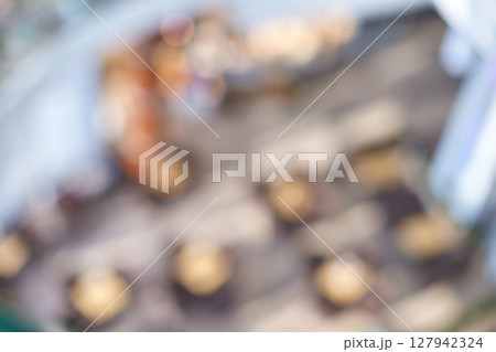 Blurry abstract view of indoor cafe with tables and chairs in bright natural 127942324