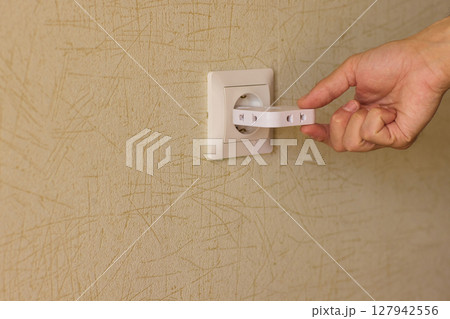 Manually plugging an electrical device into a wall outlet for convenient use and power 127942556