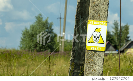 a danger sign on a lamp post( the inscription on the sign Do not get in will kill) 127942704