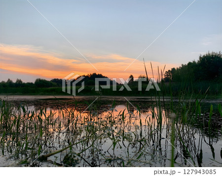 A lake with a sunset in the background. A lake with a sunset in the background. 127943085