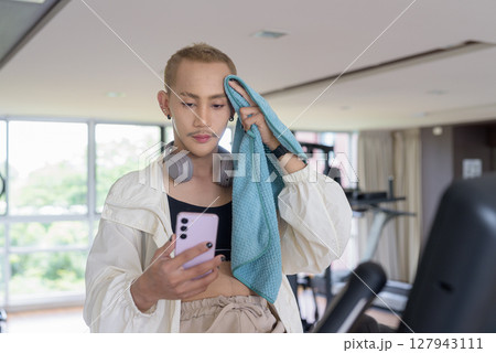 Non-binary person exercising in gym wearing sportswear 127943111