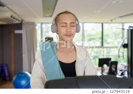 Non-binary person exercising in gym wearing sportswear 127943119