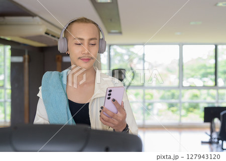 Non-binary person exercising in gym wearing sportswear 127943120