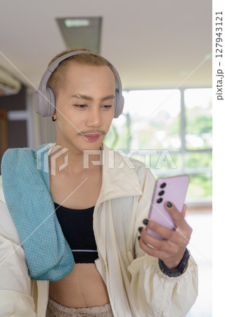Non-binary person exercising in gym wearing sportswear 127943121