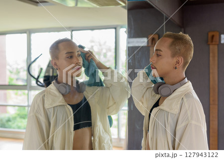 Non-binary person exercising in gym wearing sportswear 127943122