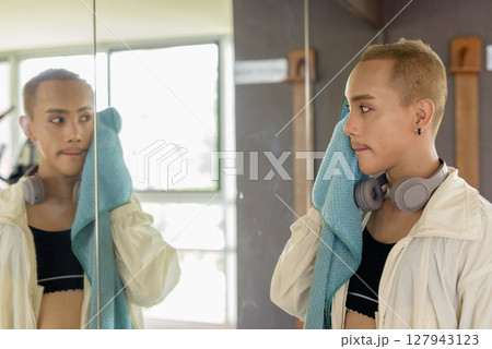 Non-binary person exercising in gym wearing sportswear Non-binary person exercising in gym wearing sportswear 127943123