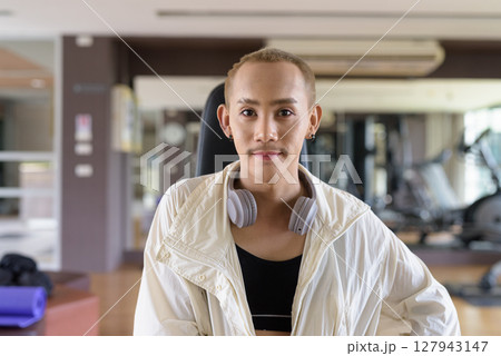Non-binary person exercising in gym wearing sportswear 127943147
