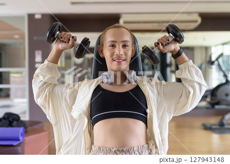 Non-binary person exercising in gym wearing sportswear Non-binary person exercising in gym wearing sportswear 127943148