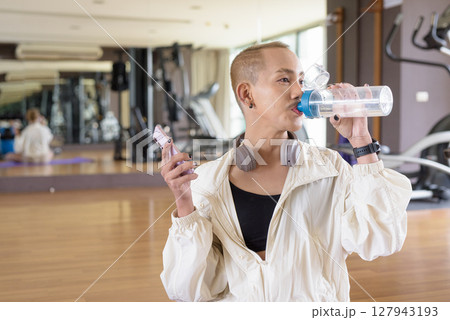 Non-binary person exercising in gym wearing sportswear 127943193
