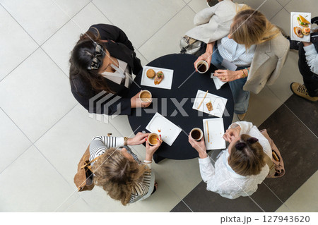 Four female managers enjoy coffee and desserts during a lunch break Four female managers enjoy coffee and desserts during a lunch break 127943620