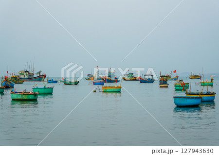 Colorful Traditional Fishing Boats Float Calmly in the Waters of Mui Ne Bay, Vietnam 127943630